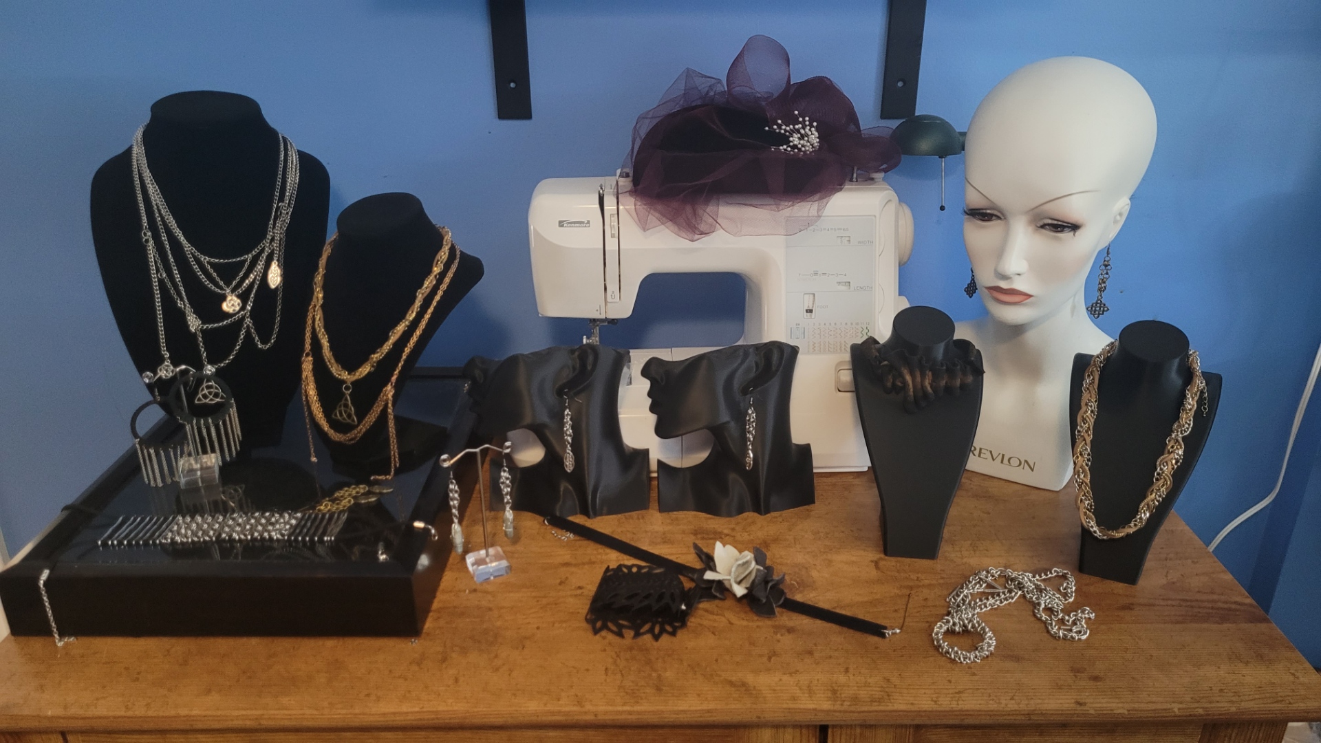 Finished talismans, leather pieces, and metal jewelry arranged together
                            on dark leather, canvas, or wood.