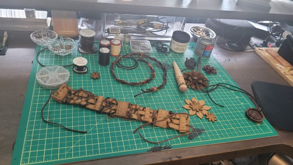Leather cord, metal findings, hardwood blanks, tools, and finished pieces.